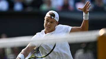 Denmark's Holger Rune returns the ball to Spain's Carlos Alcaraz during their men's singles quarter-finals tennis match on the tenth day of the 2023 Wimbledon Championships at The All England Lawn Tennis Club in Wimbledon, southwest London, on July 12, 2023. (Photo by SEBASTIEN BOZON / AFP) / RESTRICTED TO EDITORIAL USE