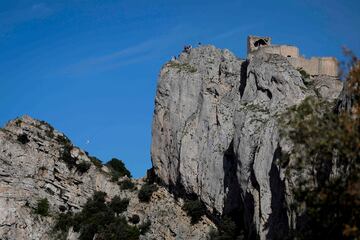 La exescaladora y exatleta de ultra trail Béatrice Fabre desciende por una tirolina mientras porta la llama olímpica en la fortaleza de Peyrepertuse, en la localidad de Duilhac-sous-Peyrepertuse, al suroeste de Francia. La antorcha olímpica recorrerá 12.000 km a través de la Francia continental y sus territorios de ultramar antes de llegar a París.