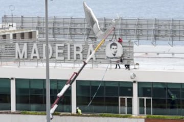 Workers add a sign bearing Cristiano Ronaldo's face to the airport exterior ahead of its 29 March name change to Madeira Cristiano Ronaldo Airport.