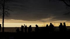 People look out towards Lake Erie and the horizon as the sky lightens during a total solar eclipse under cloudy conditions seen from Dunkirk Lighthouse & Veterans Park Museum in Dunkirk, New York, U.S., April 8, 2024. REUTERS/Elizabeth Frantz