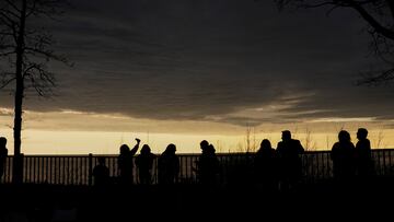 People look out towards Lake Erie and the horizon as the sky lightens during a total solar eclipse under cloudy conditions seen from Dunkirk Lighthouse & Veterans Park Museum in Dunkirk, New York, U.S., April 8, 2024. REUTERS/Elizabeth Frantz