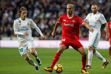 El centrocampista croata del Real Madrid Luka Modric disputa un balón con el jugador argentino del Sevilla Guido Pizarro