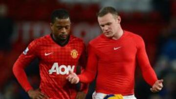 Wayne Rooney habla con Patrice Evra en un partido del Manchester.