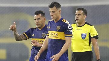 Argentina&#039;s Boca Juniors Carlos Tevez (L) gestures next to teammate Nicolas Capaldo as Uruguayan referee Christian Ferreyra conducts the closed-door Copa Libertadores group phase football match between Argentina&#039;s Boca Juniors and Venezuela&#039;s Caracas at La Bombonera stadium in Buenos Aires, on October 22, 2020, amid the COVID-19 novel coronavirus pandemic. (Photo by Natacha Pisarenko / POOL / AFP)