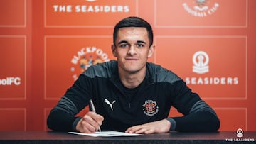 Jake Daniels firmando su primer contrato profesional con el Blackpool.