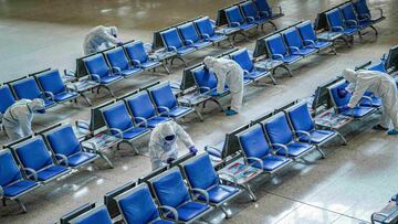 File photo: Workers in protective suits disinfect a waiting hall at the Wuhan Railway Station in March 2020.