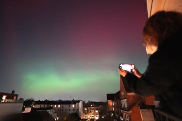 La aurora boreal brilla en el cielo nocturno sobre la ciudad hanseática de Hamburgo, Alemania. 