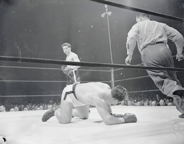 Jake LaMotta, 'Toro Salvaje', nació en Nueva York en 1921. Peleó en 106 combates de los que ganó 83 (30 por KO). Su gran rival fue Sugar Ray Robinson, al que ganó la segunda vez que se enfrentaron siendo el primer boxeador que conseguía vencerle.
El 16 de junio de 1949 consiguió por KO el título mundial de los pesos medios ante Marcel Cerdan. En la tercera defensa del título, el 14 de febrero de 1951, perdió ante Sugar Ray Robinson en una pelea que se bautizó como 'La matanza de San Valentín' debido a su crudeza. El 14 de abril de 1954 se subió al ring por última vez.
Después de su retirada compró un club nocturno. Tras perderlo por diversos problemas legales inició una carrera como comediante.
La película basada en su vida, Toro Salvaje, tuvo 8 nominaciones a los Óscar y se llevó 2 estatuillas (mejor montaje y mejor actor para Robert DeNiro).
En la imagen, ante Tiberio Mitri.