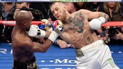 LAS VEGAS, NV - AUGUST 26: Conor McGregor (R) throws a right at Floyd Mayweather Jr. in the second round of their super welterweight boxing match at T-Mobile Arena on August 26, 2017 in Las Vegas, Nevada. Mayweather won by 10th-round TKO.   Ethan Miller/Getty Images/AFP
 == FOR NEWSPAPERS, INTERNET, TELCOS &amp; TELEVISION USE ONLY ==