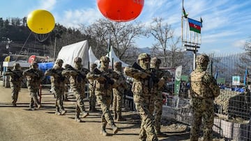 Azerbaijani servicemen stand guard at a checkpoint at the Lachin corridor, the Armenian-populated breakaway Nagorno-Karabakh region's only land link with Armenia, as Azerbaijani environmental activists protest against what they claim the illegal mining, on December 27, 2022. - Azerbaijani activists who have blocked the sole road connecting Karabakh with Armenia rejected on December 26 Yerevan's accusations of provoking a humanitarian crisis in the enclave. But locals in Karabakh interviewed by AFP decried the dire consequences of the blockade, which they say is aimed at chasing ethnic Armenians from the region. (Photo by TOFIK BABAYEV / AFP) (Photo by TOFIK BABAYEV/AFP via Getty Images)