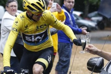 Chris Froome con una copa de champán brindando con su coche de equipo por su victoria en el Tour de Francia 2015.