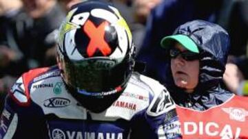 Jorge Lorenzo se mira el estado de su dedo tras la caída.