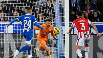 Alaves' Spanish midfielder #24 Joan Jordan Moreno (L) goes for a loose ball before scoring as Athletic Bilbao's Spanish goalkeeper #01 Unai Simon fails to stop the ball during the Spanish league football match between Deportivo Alaves and Athletic Club Bilbao at the Mendizorroza stadium in Vitoria on December 15 , 2024. (Photo by ANDER GILLENEA / AFP)