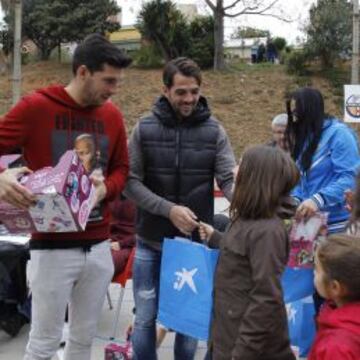 Javi López y Víctor Sánchez, entregando regalos a las niñas de la Guineueta.