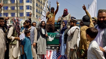 Members and supporters of the Taliban stand on a U.S. flag as they hold a rally to mark the third anniversary of the fall of Kabul, in Kabul, Afghanistan, August 14, 2024. REUTERS/Sayed Hassib