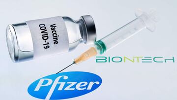 This illustration picture taken on November 23, 2020 shows a bottle reading &quot;Vaccine Covid-19&quot; and a seringe next to the Pfizer and Biotntech logo. - The European Commission has signed five contracts to pre-order vaccines, among which with the U