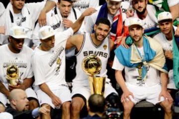 En 2014: Kawhi Leonard #2, Tony Parker #9, Tim Duncan #21, Manu Ginobili #20, and Patty Mills #8 celebran con el trofeo Larry O'Brien.