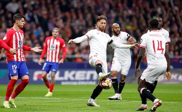 El defensa del Sevilla intenta controlar el balón dentro de su área.