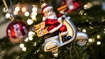 24 December 2022, Lower Saxony, Göttingen: A Christmas tree is decorated with a Santa Claus figure on a motorcycle, a string of lights and Christmas balls.  In Germany, Christmas Eve has become the day for Christians to give presents after dark. Photo: Swen Pförtner/dpa (Photo by Swen Pförtner/picture alliance via Getty Images)