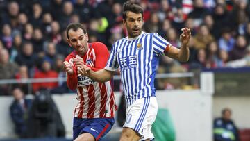 Xabi Prieto y Godín en el duelo entre la Real Sociedad y el Atlético.