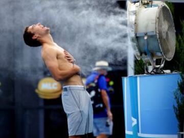 Tenista polaco Jerzy Janowicz refrescándose ante un gran ventilador con agua durante el Abierto de Tenis de Australia en Melbourne