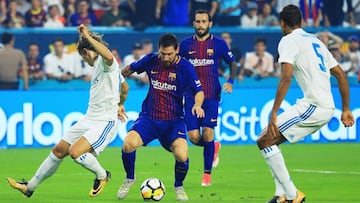 MIAMI GARDENS, FL - JULY 29: Lionel Messi #10 of Barcelona scores against the defense of Raphael Varane #5 and Luka Modric #10 of Real Madrid in the first half during their International Champions Cup 2017 match at Hard Rock Stadium on July 29, 2017 in Miami Gardens, Florida.   Chris Trotman/Getty Images/AFP
 == FOR NEWSPAPERS, INTERNET, TELCOS &amp; TELEVISION USE ONLY ==