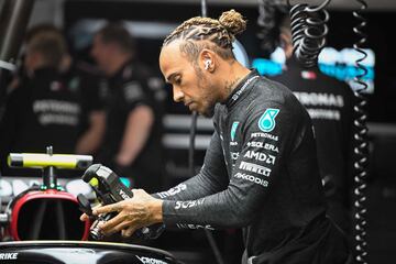 El piloto británico de Mercedes, Lewis Hamilton, revisa su coche en el garaje antes de la segunda sesión de práctica.