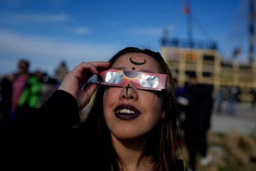 Personas observan un eclipse solar anular en Puerto San Julián, Argentina.