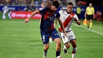 El centrocampista del Huesca Gonzalo Melero (i) y el centrocampista argentino del Rayo Vallecano Oscar Guido luchan por el bal&oacute;n durante el partido de la cuarta jornada que disputan en el campo de f&uacute;tbol El Alcoraz.