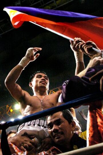 Pacquiao logró defender su título super gallo cuatro veces con su entrenador Freddie Roach todo para enfrentarse a Marco Antonio Barrera, el combate que definió su carrera. Subió de peso a la división pluma y fue reconocido como campeón del mundo tras la victoria. Imagen años después en 2006 tras vencer a Óscar Larios.