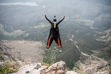 Un paracaidista realiza un espectacular salto BASE desde Becco dellAquila, el punto de salida en la cima del Monte Brento, cerca de Trento (Italia). El Monte Brento, próximo al lago de Garda, es uno de los acantilados de salto BASE más famosos del mundo, con una pared de 1.000 metros de altura y una extensa superficie de aterrizaje.