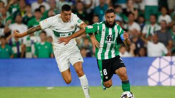 SEVILLA, 15/08/2022.- El centrocampista francés del Real Betis Nabil Fekir (d) se escapa del chileno Enzo Roco, del Elche CF, durante el partido de la primera jornada de Liga en Primera División que Real Betis y Elche CF disputan hoy lunes en el estadio Benito Villamarín, en Sevilla. EFE/José Manuel Vidal
