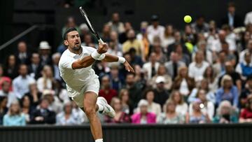 Serbia's Novak Djokovic returns the ball to Denmark's Holger Rune during their men's singles tennis match on the eighth day of the 2024 Wimbledon Championships at The All England Lawn Tennis and Croquet Club in Wimbledon, southwest London, on July 8, 2024. (Photo by Ben Stansall / AFP) / RESTRICTED TO EDITORIAL USE