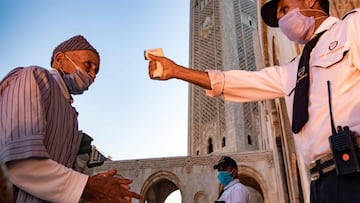 A mask-clad worker measures the body temperature of incoming Muslim worshippers (COVID-19 coronavirus pandemic precaution) arriving for prayers at the Hasan II mosque, one of the largest in the African continent, in Morocco&#039;s Casablanca on June 16, 2