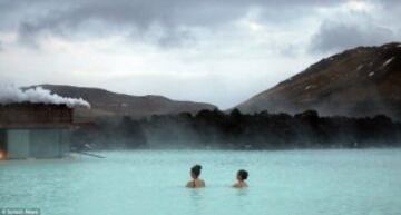 Kim y su amiga a lo lejos en medio del paisaje volcánico que rodea la laguna y con el vapor condensado alrededor