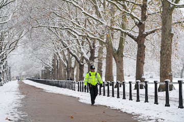 Un policía camina por uno de los parques de la ciudad. 