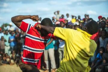 Participants in the Musangwe traditional bare-knuckle boxing tournament fight in the Tshifudi village, Venda district of the South African Limpopo province, on December 26, 2015. / AFP / MUJAHID SAFODIEN