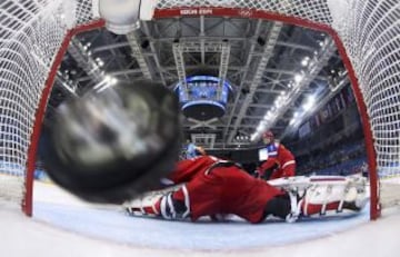 El disco vuela en la red para el segundo gol de Finlandia junto al portero de Rusia Prugova durante el primer período de hockey sobre hielo de juegos de clasificación de sus mujeres en los Juegos Olímpicos de Invierno de Sochi 2014