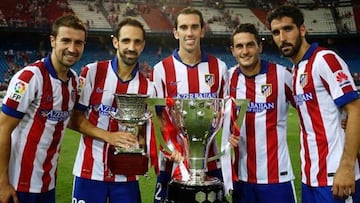 Varios jugadores del Atl&eacute;tico con los trofeos de Liga y Supercopa