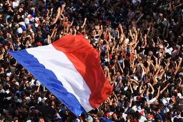 Supporters wave French national flags while they gather at the Place Charles de Gaulle up the Champs-Elysees avenue in Paris on July 16, 2018 as they wait for the arrival of the French national football team for celebrations after France won the Russia 20