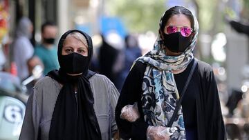 Iranian women wearing protective masks due to the COVID-19 pandemic, walk along a street in the capital Tehran on July 1, 2020. (Photo by ATTA KENARE / AFP)