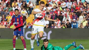 MADRID, 25/11/2023.- El portero del FC Barcelona Iñaki Peña (d) agarra el balón ante el delantero del Rayo Vallecano Jorge de Frutos (c) durante el partido de LaLiga EA Sports que ha enfrentado al Rayo Vallecano y el FC Barcelona en el estadio de Vallecas, este sábado. EFE/Kiko Huesca