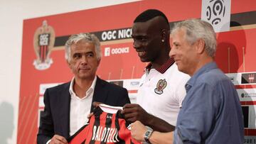 Nice&#039;s football club new signing Italian forward Mario Balotelli (C) smiles as he poses with his new jersey between Nice&#039;s French club president Jean-Pierre Rivere (L) and Nice&#039;s Swiss head coach Lucien Favr