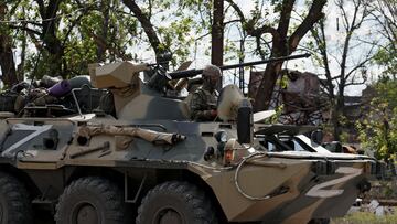 A service member of pro-Russian troops rides an armoured personnel carrier escorting buses with service members of Ukrainian forces who have surrendered after weeks holed up at Azovstal steel works in the course of Ukraine-Russia conflict in Mariupol, Ukraine May 17, 2022. REUTERS/Alexander Ermochenko