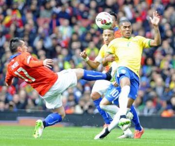 Douglas disputa la pelota con Gary Medel.