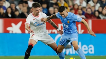 SEVILLA, 24/2/2025.- El defensa del Sevilla José Carmona (i) lucha con Dani Rodríguez, del Mallorca, durante el partido de LaLiga que Sevilla FC y RCD Mallorca disputan este lunes en el estadio Ramón Sánchez-Pizjuán. EFE/José Manuel Vidal