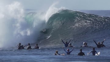 El surfista Natxo Gonzalez saliendo de un tubo en La Santa (Lanzarote, Islas Canarias) ante la mirada de varios surfistas desde el agua que celebran con los brazos en alto la exhibición de surf del vasco, durante el Quemao Class, el 31 de diciembre del 2021.