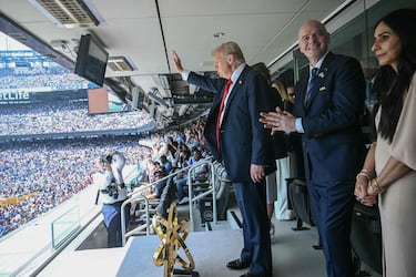 Donald Trump saluda a los aficionados, mientras Gianni Infantino aplaude y su esposa, Leena Al Ashqar, voltea a la grada. (Photo by Brendan SMIALOWSKI / AFP)