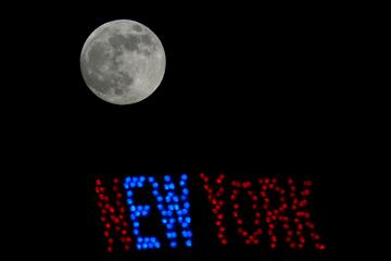 La luna sale junto a un Big Tex de neón en la Feria Estatal de Texas en Dallas.