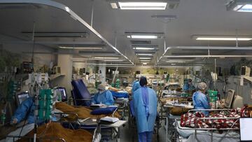 Health workers care for patients infected with COVID-19 at the full emergency room of the Nossa Senhora da Conceiao hospital in Porto Alegre, Rio Grande do Sul State, in southern Brazil, on March 11, 2021, amid the novel coronavirus pandemic. - The state of Rio Grande do Sul has now imposed severe restrictions due to the rapid increase in COVID-19 cases. (Photo by SILVIO AVILA / AFP)